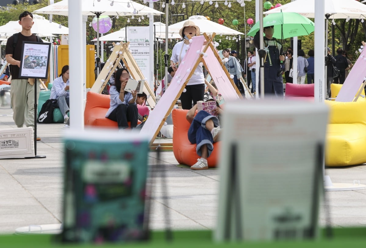 세계 책과 저작권의 날인 23일 서울 종로구 광화문광장에서 열린 '광화문 책마당'을 찾은 시민들이 책을 읽고 있다.