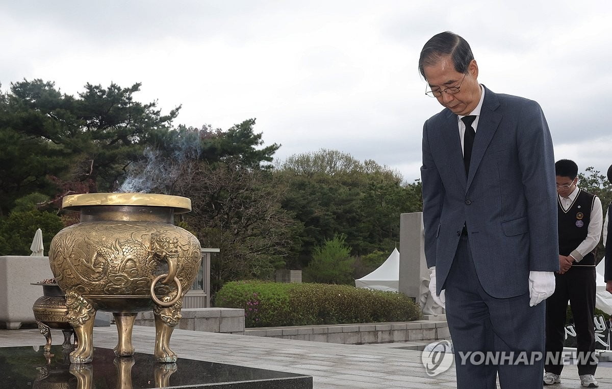 한덕수 대통령 권한대행 국무총리가 19일 서울 강북구 국립 4·19민주묘지에서 열린 제65주년 4·19 혁명 기념식에서 헌화 및 분향을 마치고 묵념하고 있다.(연합뉴스)
