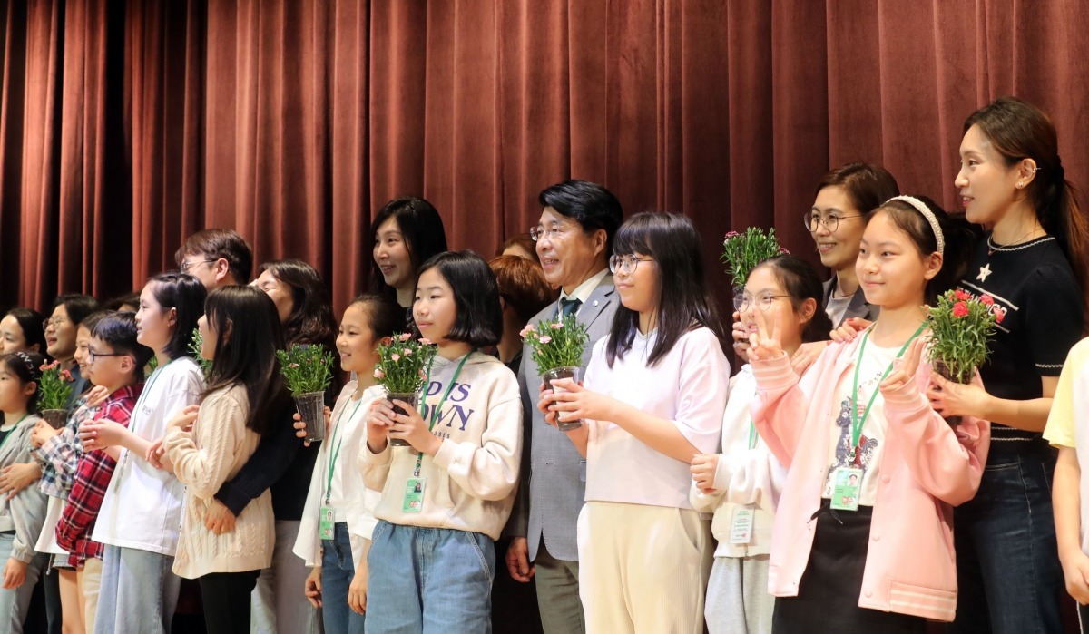 서강석 송파구청장이 2일 오후 청사 대강당에서 열린 송파꿈나무 어린이 명예기자단 우수활동자 표창장 및 신규 기자 위촉장 수여식에서 기자단 어린이들에게 어버이날을 맞아 참석한 학부모들과 함께 카네이션을 받고 기념 촬영을 하고 있다.  (송파구 제공)