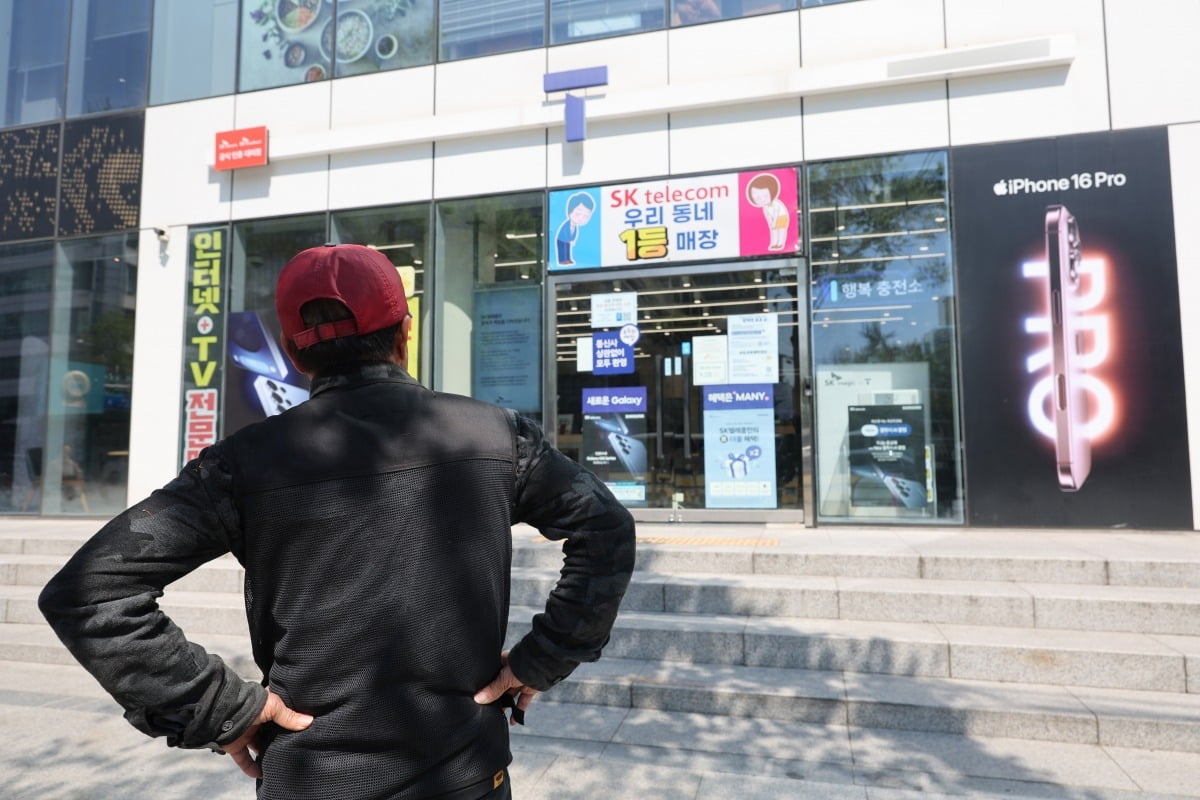 SK텔레콤이 가입자 유심(USIM) 정보 유출 사태로 오는 5일부터 신규 가입자 모집을 중단한다고 밝힌 2일 서울 시내의 한 SK텔레콤 대리점 앞에서 한 소비자가 유심 재고 소진 안내문을 한참 바라보고 있다. /사진=연합뉴스
