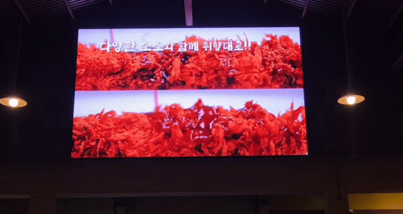 예산상설시장 장터광장 TV 광고판에 더본코리아의 '빽라거' 캔맥주를 판매하는 매장의 광고가 나오는 모습. /영상=이민형 기자