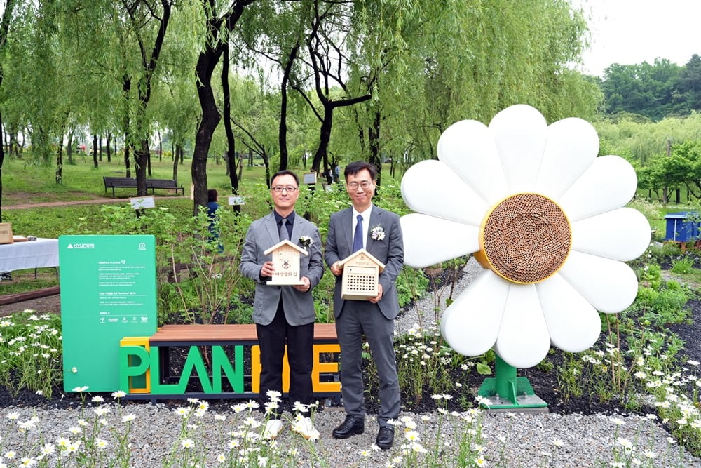 지난 20일 서울 강북구 북서울꿈의숲에서 진행된 ‘꿀벌 서식지’ 개장식에서 엄홍석 현대엔지니어링 커뮤니케이션실장(왼쪽)과 이수연 서울시 정원도시국장이 기념 사진을 찍고 있다./현대엔지니어링 제공 