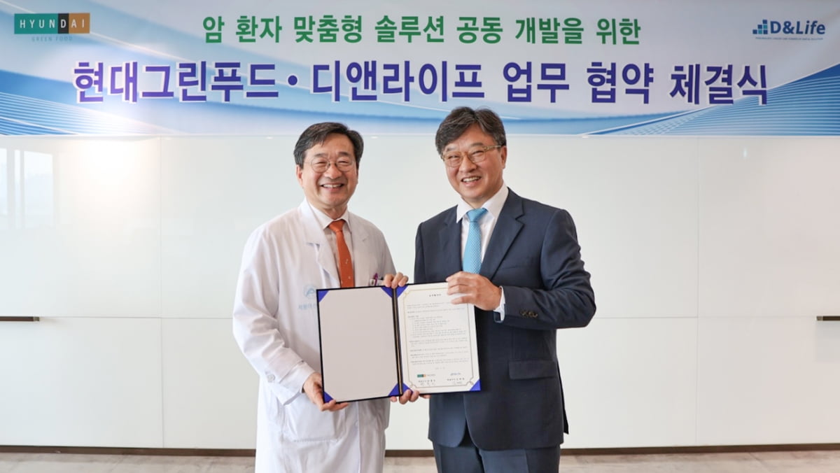 박홍진 현대그린푸드 사장(왼쪽)과 김태원 디앤라이프 대표이사가 28일 서울 송파구 서울아산병원에서 열린 암환자 맞춤형 솔루션 공동 개발을 위한 업무협약을 맺고 있다. 현대그린푸드 제공