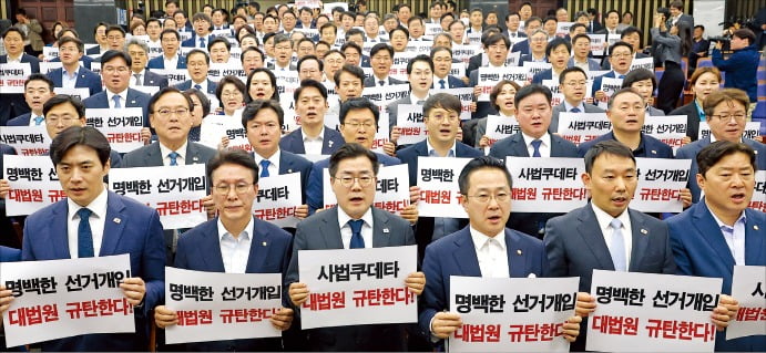 박찬대 당 대표 직무대행(앞줄 왼쪽 세 번째) 등 더불어민주당 의원들이 1일 국회에서 열린 의원총회에서 대법원이 이재명 후보에게 내린 공직선거법 위반 유죄 취지 파기환송 결정을 규탄하고 있다. /연합뉴스