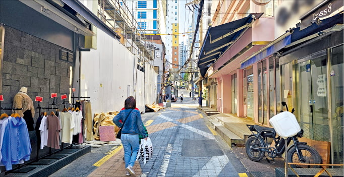 5일 서울 ﻿ 이화여대 앞 골목에서 폐업한 매장들 사이로 한 시민이 지나가고 있다.  권용훈 기자
