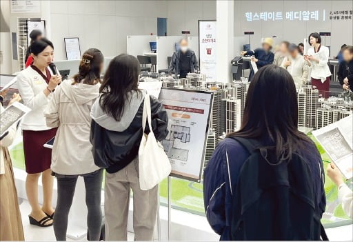 같은 날 개관한 은평구 ‘힐스테이트 메디알레’ 견본주택 내부 모형 앞에서 방문객이 도우미의 설명을 듣고 있다. /현대건설 제공