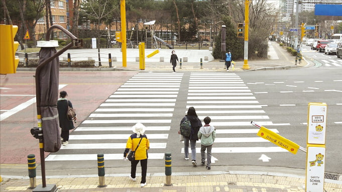 경기 화성시 동화초교 앞 스쿨존에서 어린이들이 횡단보도를 건너고 있다. 이곳에는 무단횡단을 감지해 신호를 제어하고 자동으로 안전 바를 내려주는 인공지능(토토사이트 쿠폰) 보행안전 시스템이 설치돼 있다. 화성시 제공