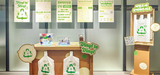 현대백화점이 ‘비닐 투 비닐’ 프로젝트를 알리고자 사내에 설치한 이벤트 부스에 폐비닐을 재활용해 만든 비닐봉투가 걸려 있다.  현대백화점 제공