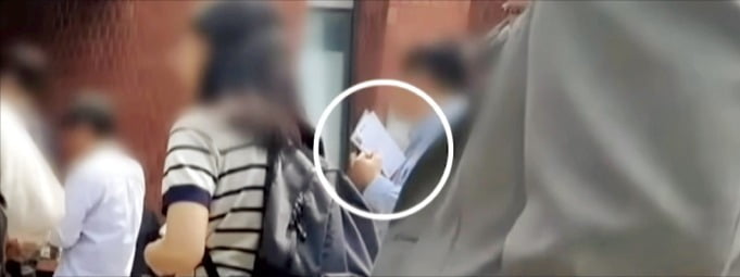29일 ﻿서울 신촌﻿ 사전투표소에서﻿ 유권자가﻿ 투표용지를 들고 투표소 밖에 줄을 서 있다. /사진=YTN 영상 캡처