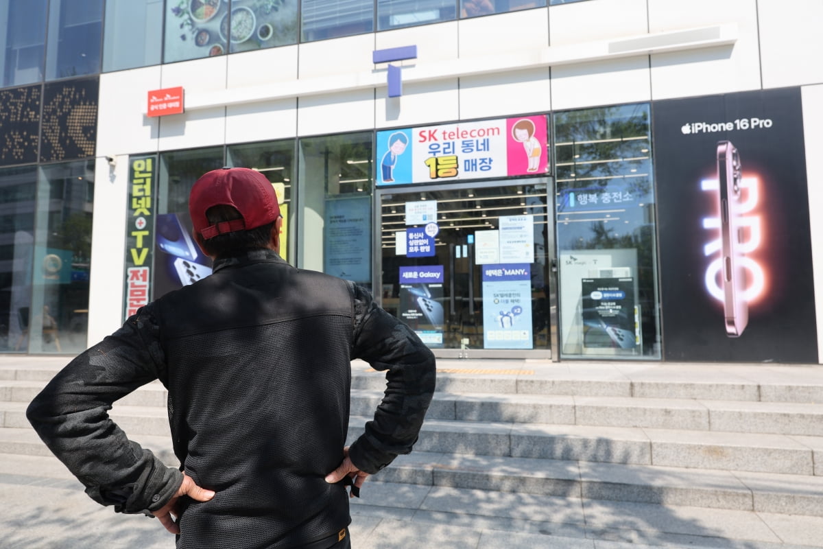 SK텔레콤이 가입자 유심(USIM) 정보 유출 사태로 오는 5일부터 신규 가입자 모집을 중단한다고 밝힌 2일 서울 시내의 한 SK텔레콤 대리점 앞에서 한 소비자가 유심 재고 소진 안내문을 한참 바라보고 있다. 사진=연합뉴스