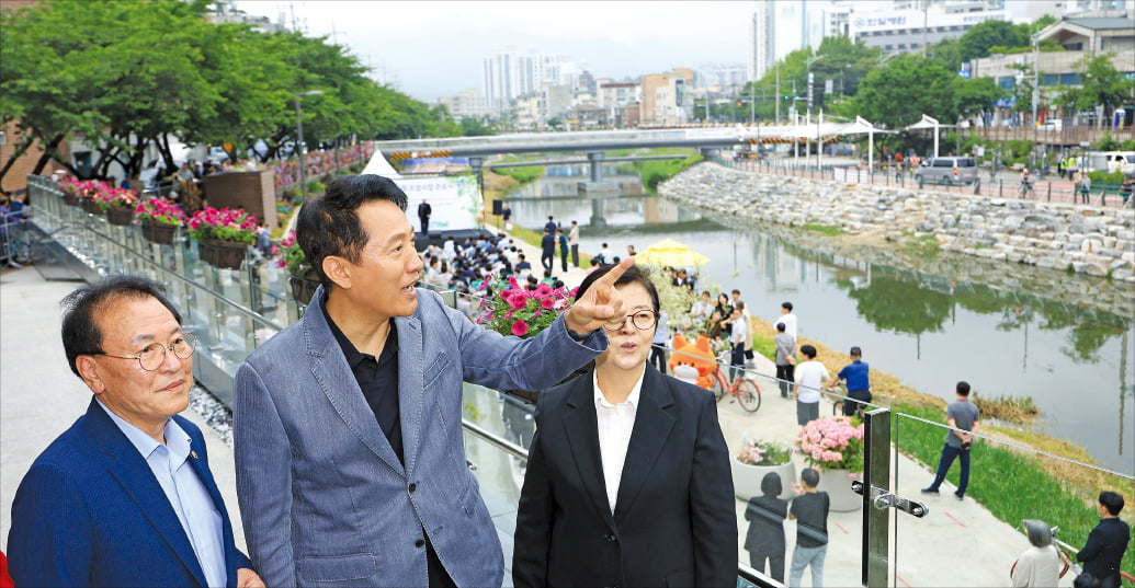 < 우이천 살펴보는 오세훈 > 오세훈 서울시장(가운데)이 지난 16일 서울 강북구 우이천에서 열린 수변활력거점 개장식에 참석해 이순희 강북구청장(오른쪽)과 함께 거점 테라스 등 시설을 살펴보고 있다.  뉴스1
