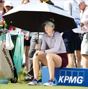 넬리 코르다가 지난 20일 미국 텍사스주 프리스코에서 열린 KPMG 위민스 PGA 챔피언십 1라운드 7번홀 티잉 구역에서 우산을 쓴 채 앉아 앞 조 선수들의 경기를 지켜보고 있다.  AFP연합뉴스