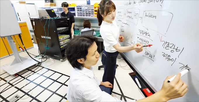 KT와 삼성리서치 연구진이 인공지능(AI) 기반 무선망 최적화 기술 개발을 논의하고 있다.  KT 제공