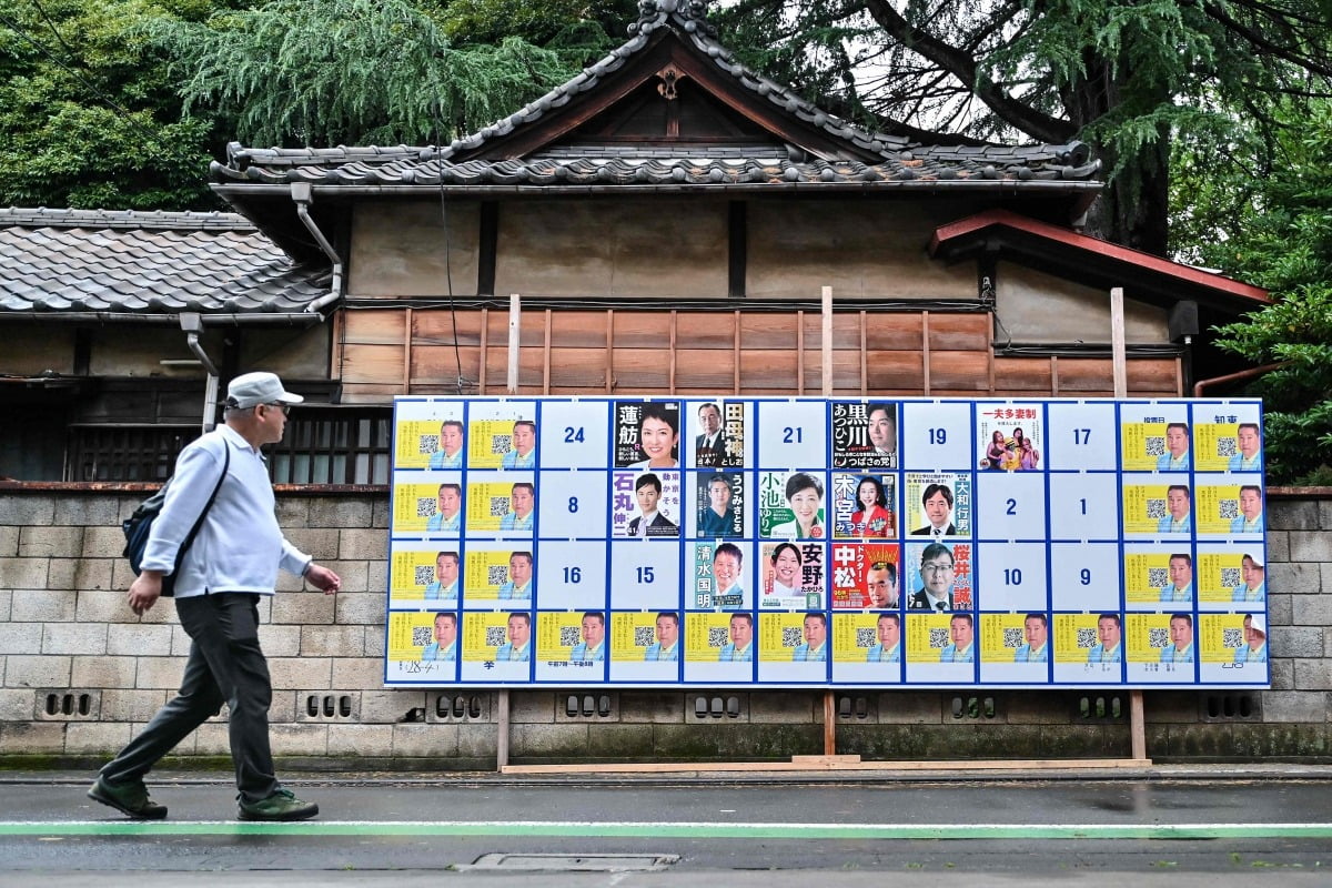 지난해 6월 일본 도쿄지사 선거 게시판 앞을 지나는 일본 노인. 사진=연합AFP