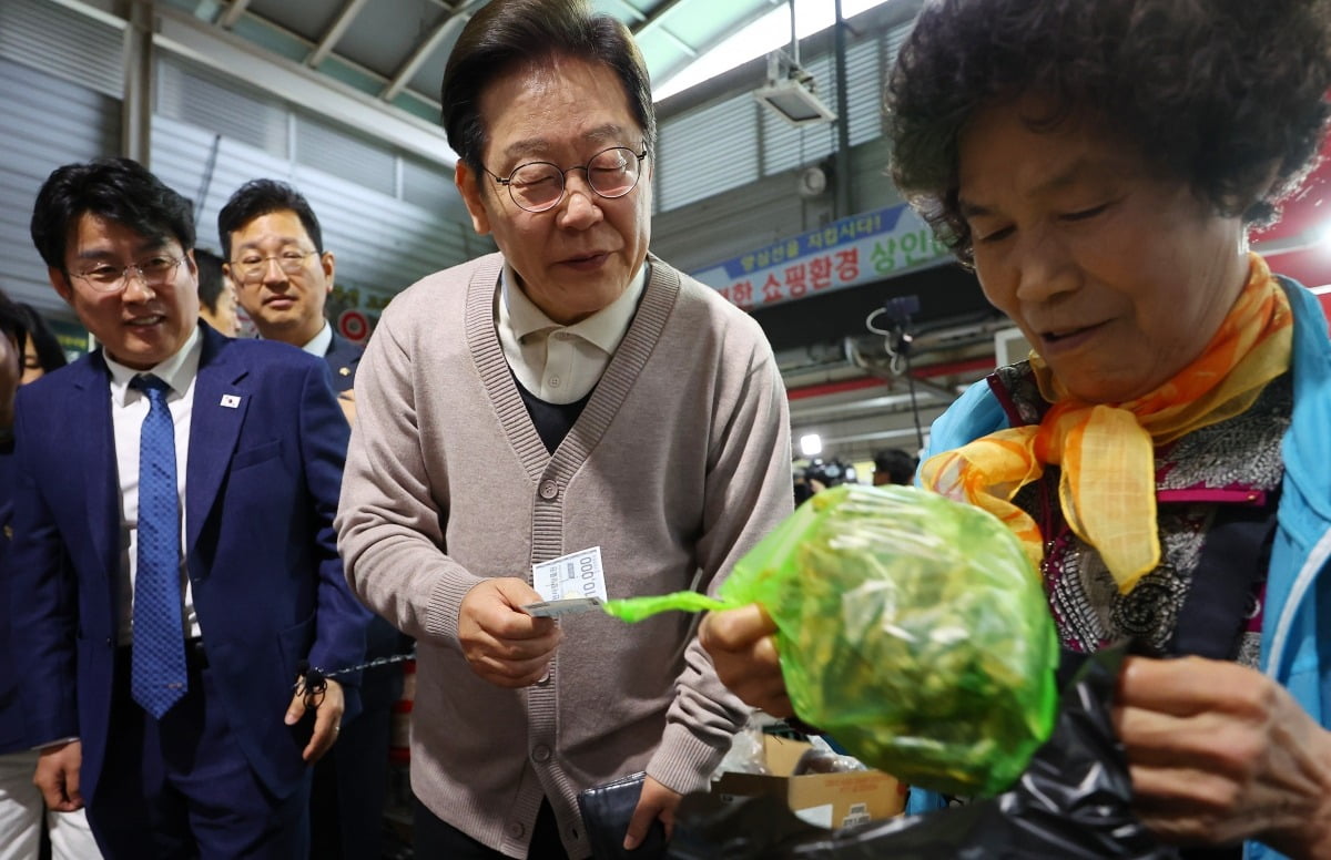 이재명 대통령이 제3차 골목골목 경청투어로 경북지역 방문에 나선 지난달 9일 경북 영천시 영천공설시장을 찾아 한 가게에서 영천사랑상품권으로 말린 고추를 구매하고 있다./사진=연합뉴스