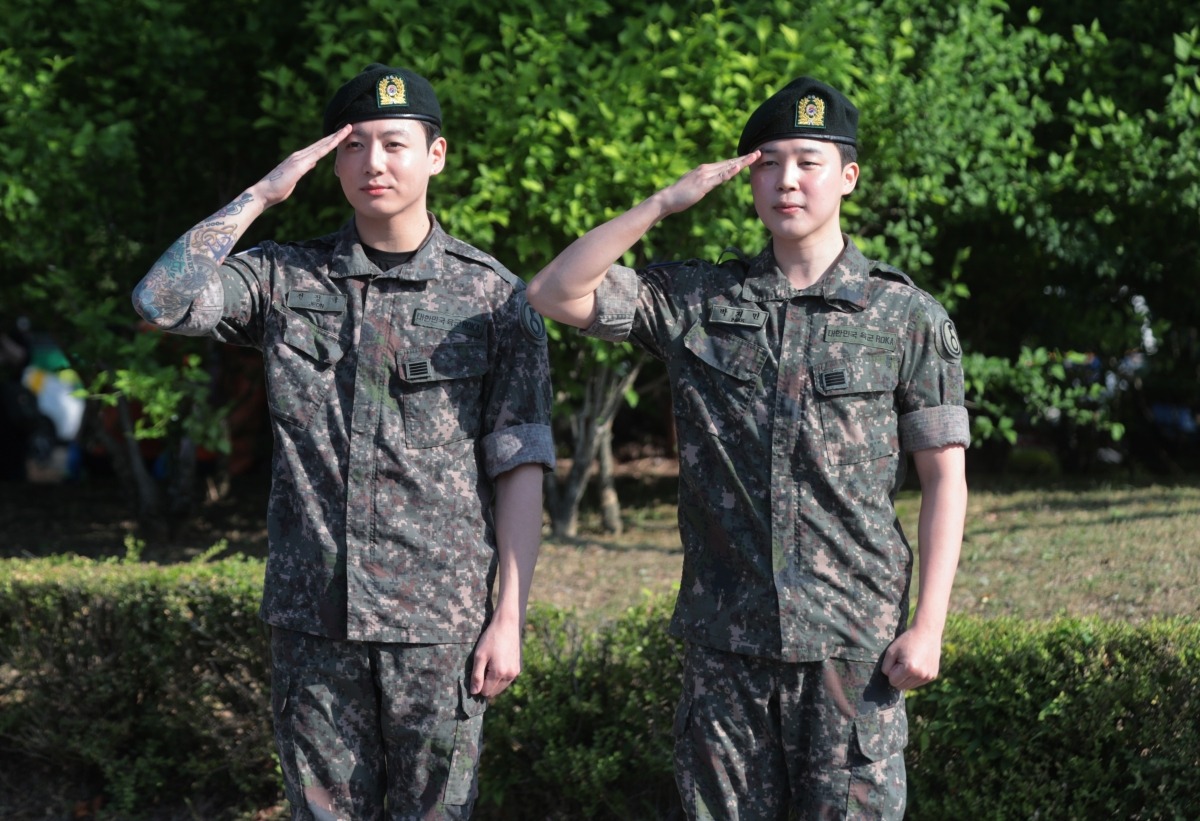 육군 현역 복무를 마치고 만기 전역한 그룹 방탄소년단(BTS)의 지민과 정국이 11일 경기도 연천군 연천공설운동장에서 취재진과 팬들을 향해 거수 경례하고 있다./사진=연합뉴스