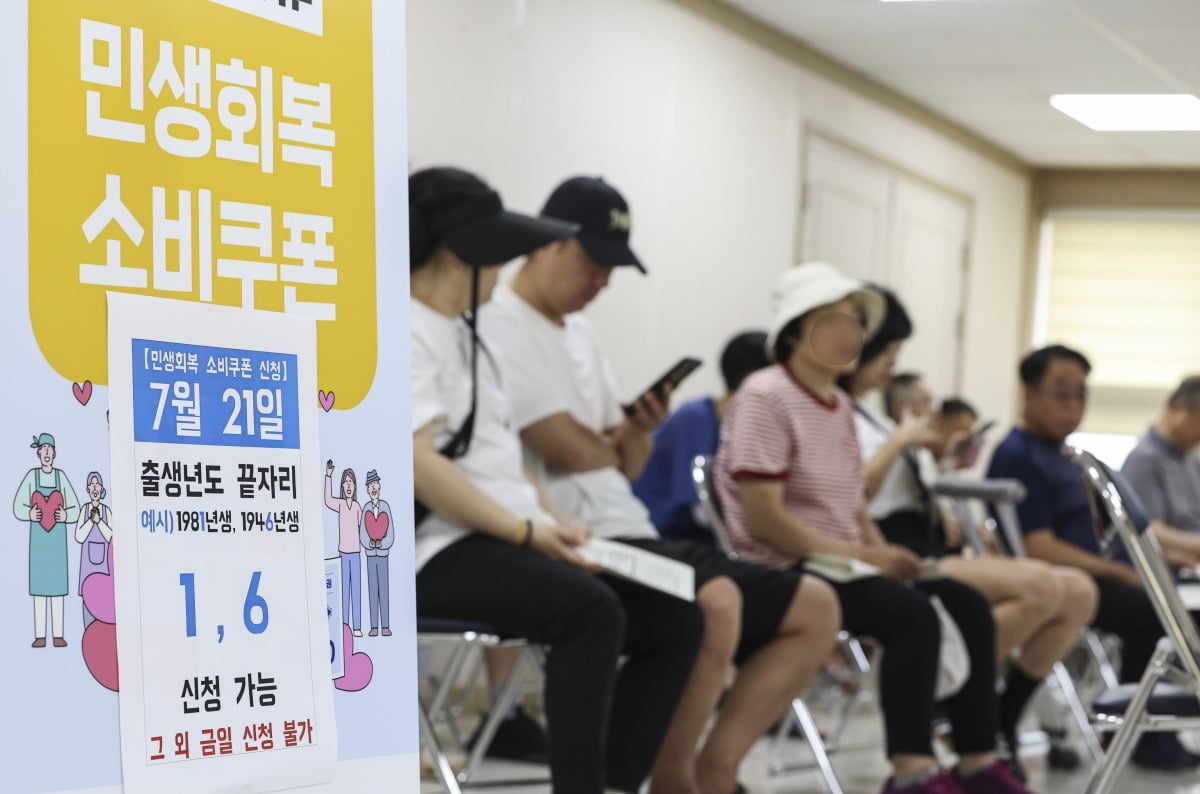 민생회복 소비쿠폰 신청 첫 날인 21일 오전 서울 구로구 구로3동 주민센터에서 시민들이 민생회복 소비쿠폰을 신청하고 있다.