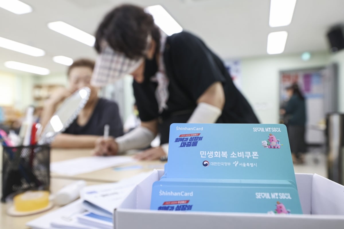 민생회복 소비쿠폰 신청 첫 날인 21일 오전 서울 구로구 항동 주민센터에서 시민들이 민생회복 소비쿠폰을 신청 하고 있다.