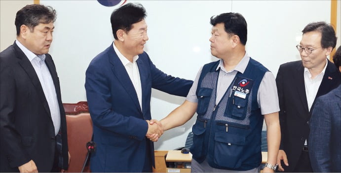 < 극적 합의 > 10일 정부세종청사 고용노동부에서 열린 최저임금위원회 제12차 전원회의에서 내년 최저임금을 시간당 1만320원으로 17년 만에 합의로 결정한 뒤 사용자위원인 류기정 한국경영자총협회 전무(왼쪽)와 근로자위원인 류기섭 한국노동조합총연맹 사무총장이 악수를 하고 있다.  /연합뉴스