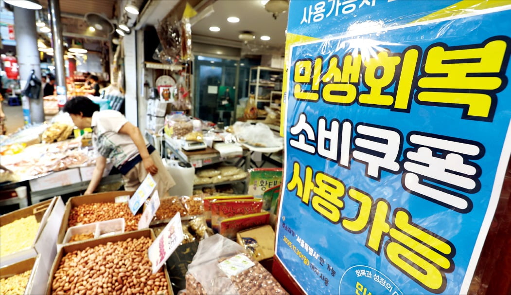 <“소비쿠폰 우리 가게서 쓰세요”> 민생회복 소비쿠폰 지급 첫날인 21일 서울의 한 전통시장 좌판에 관련 안내문이 붙어 있다. 전통시장은 대표적인 소비쿠폰 사용처 중 한 곳으로 대형마트, 백화점, 면세점 등 지역 상권 활성화 취지에 맞지 않는 매장에선 사용할 수 없다.  뉴스1