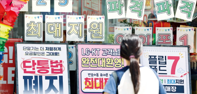 단말기 유통구조 개선에 관한 법률(단통법) 폐지 첫날인 22일 한 시민이 휴대폰 매장의 홍보 문구를 살펴보고 있다.  뉴스1