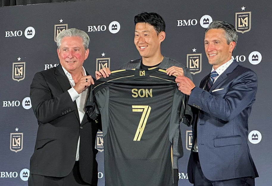  손흥민이 7일(한국시간) 미국 로스앤젤레스(LA) BMO 스타디움에서 열린 LAFC 기자회견에서 베넷 로즌솔 공동 구단주(왼쪽), 존 소링턴 회장과 함께 등번호 7번이 새겨진 유니폼을 보여주고 있다. 연합뉴스