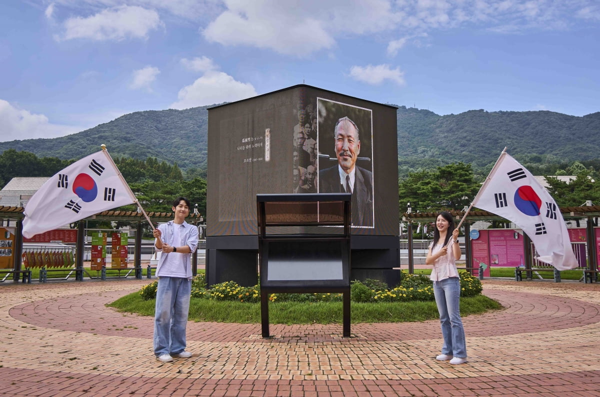 고화질로 복원한 독립운동가의 영상을 관람하고 또렷하게 복원된 독립운동가의 육성을 들을 수 있는 LED 미디어큐브 앞에서 모델들이 태극기를 휘날리고 있다. 사진=SK텔레콤 