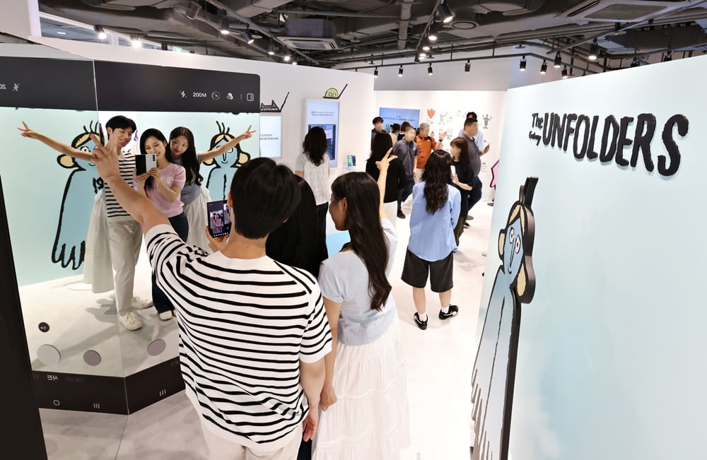 서울 코엑스 '더 갤럭시 언폴더스' 체험존 방문객들이 갤럭시Z폴드7을 이용해 아티스트 '장 줄리앙'의 캐릭터와 함께 인증샷을 찍고 있다. 사진=삼성전자