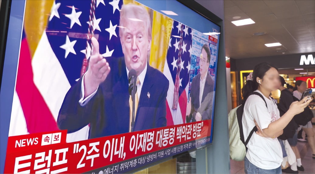 시민들이 지난 31일 서울역 대기실에서 한·미 관세협상 타결과 관련한 뉴스가 나오는 TV 앞을 지나고 있다. 사진=임형택 기자
