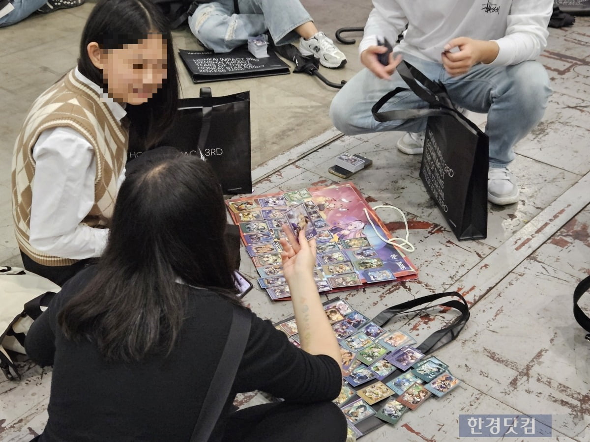 지난 10일 일산 킨텍스에서 열린 '호요랜드2025' 행사장에서 관람객들이 포토카드를 교환하고 있다. 사진=박수빈 기자 
