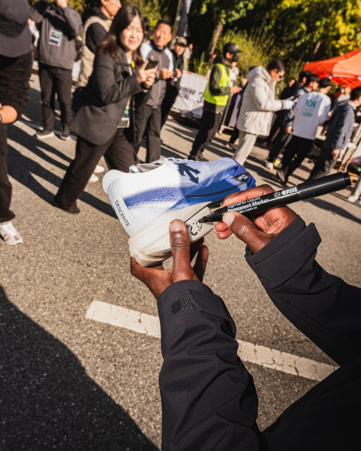 지난 2일 JTBC서울마라톤에서 우승한 리틀 닉 키툰두가 러닝화에 사인을 하고 있다. 데상트 제공