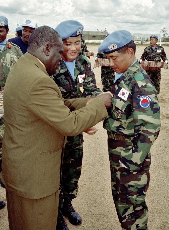 Alioune Blondin Beye (left), the Secretary-General's Special Representative for Angola, pins a United Nations Medal on Major Choi Kong Lyee, Field Engineer Commander of the Korean Engineering Corp who served with UNAVEM. The Corp is responsible for renovating eight bridges throughout Angola that had been destroyed in the civil conflict.