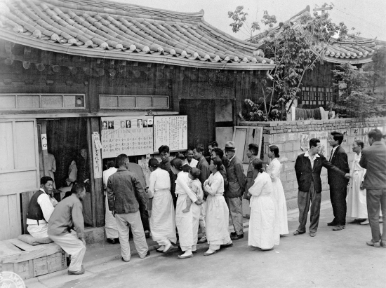 Koreans line up in one of the polling booths in Chunchon, to cast their votes in the first free election in the history of the Republic of Korea, under the supervision of the United Nations Commission.