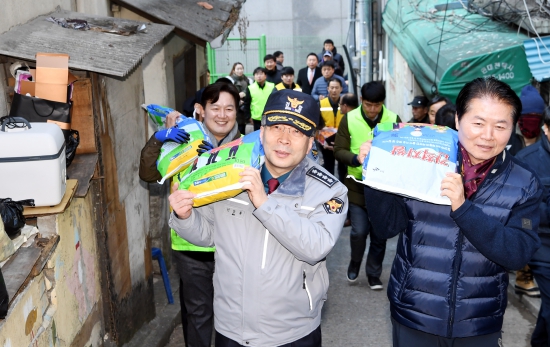 민갑룡 경찰청장(왼쪽)과 김병원 농협중앙회 회장이 18일 서울 중구 남대문 쪽방촌을 방문해 주민들에게 생활용품을 전달하고 있다.   /허문찬기자  sweat@hankyung.com