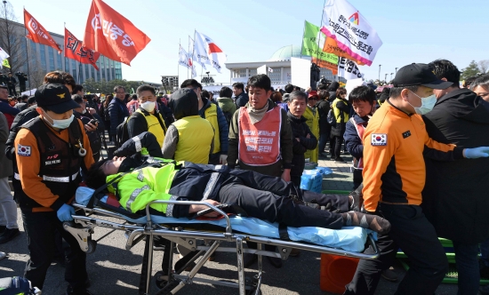 3일 오후 민주노총 조합원들이 국회 앞에서 노동법 개악 저지 등을 촉구하며 경내 진입을 시도하다 충돌과정에서 쓰러진 경찰이 구급대원에 실려가고  있다./김범준기자 bjk07@hankyung.com